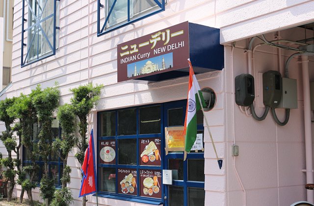 ピンクの建物。入口の国旗が目印です。